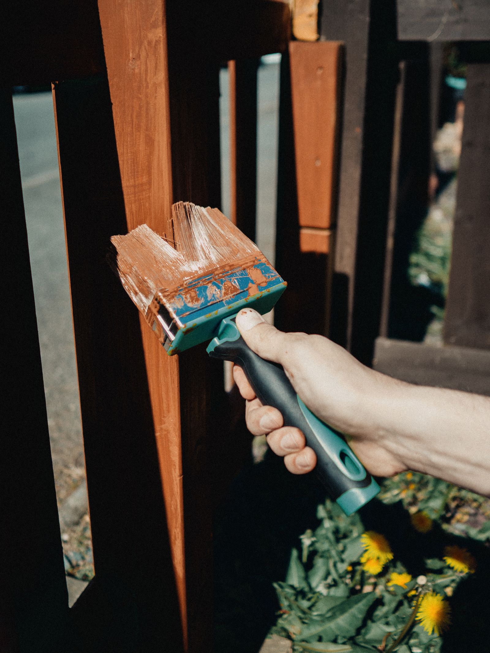 Applying stain to a fence picket by hand